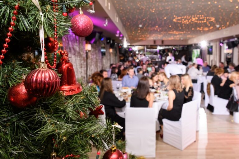 Staff at a corporate party with a Christmas tree in the foreground.